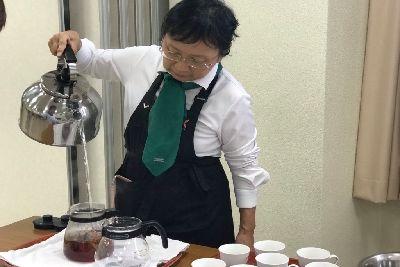 角田先生が高い位置からティーポットにお湯を注いでいる写真