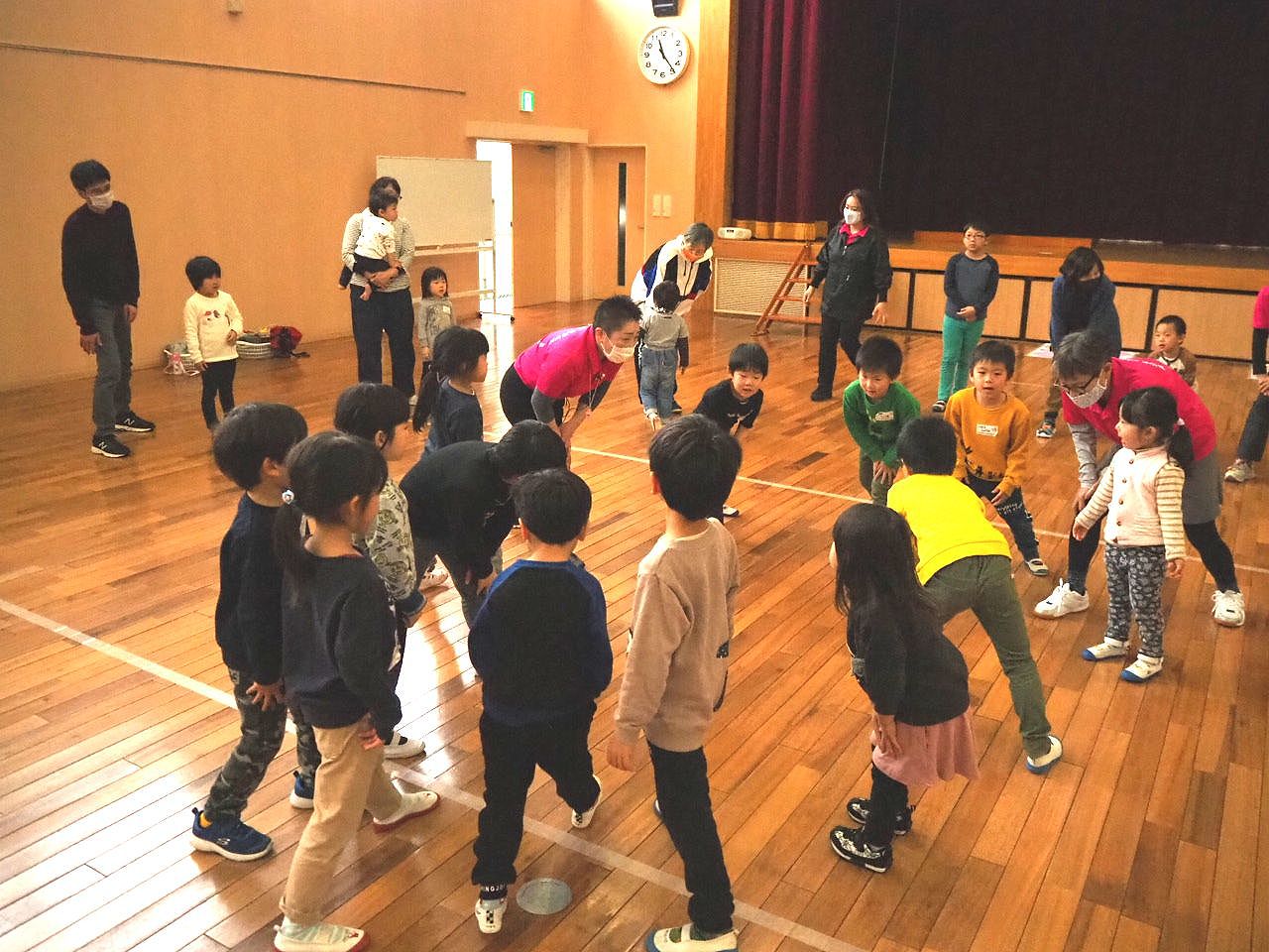 円に集まりチクサクコールをする子どもたちとスタッフ