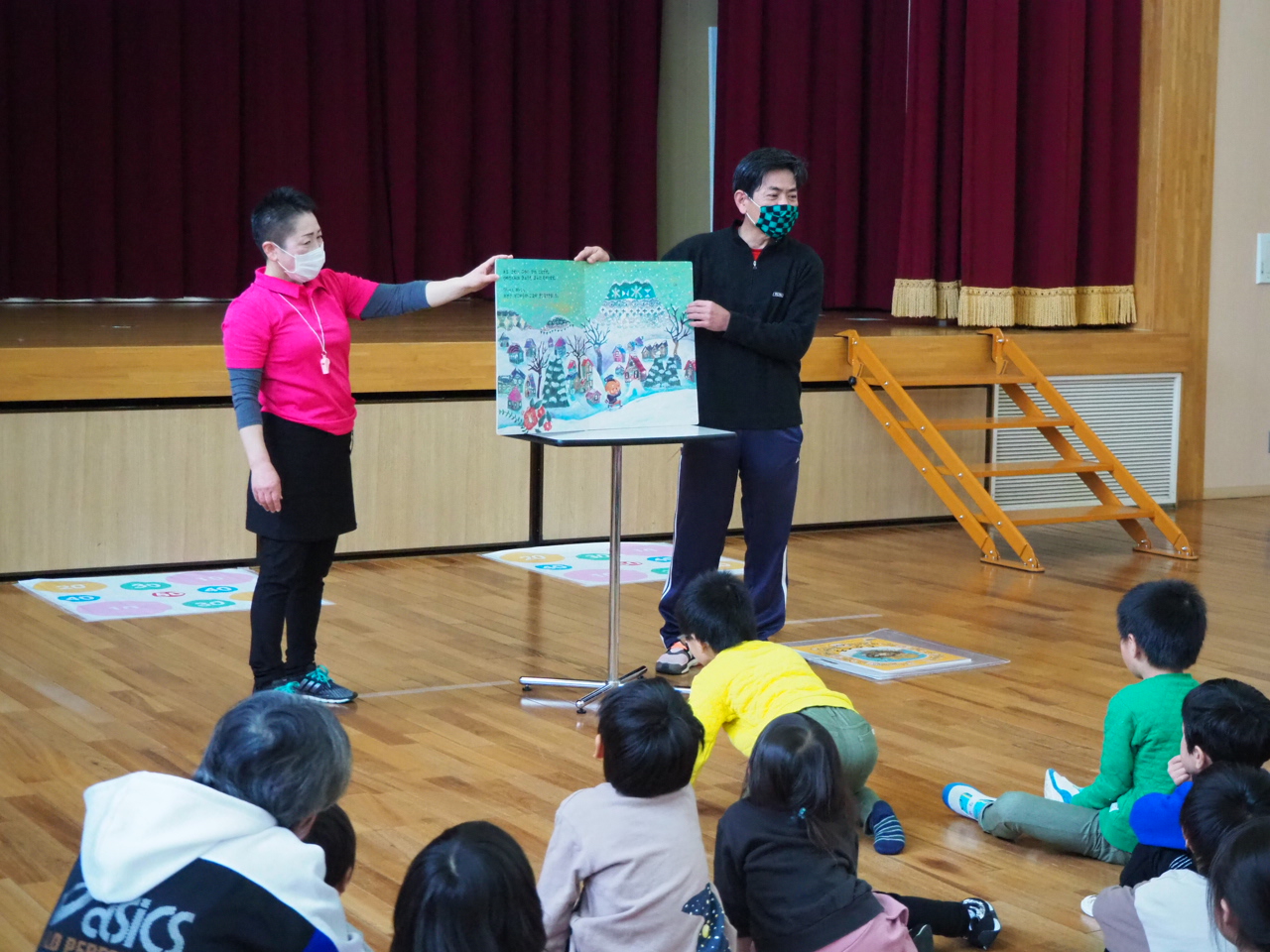 大きな絵本を読み聞かせる様子