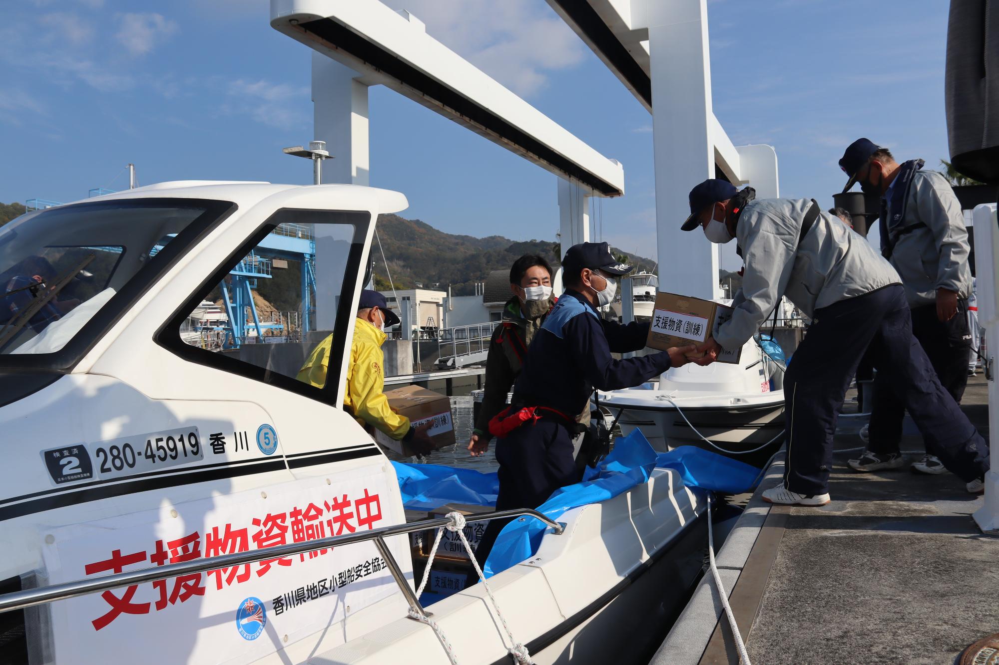 小型船に支援物資を積み込み