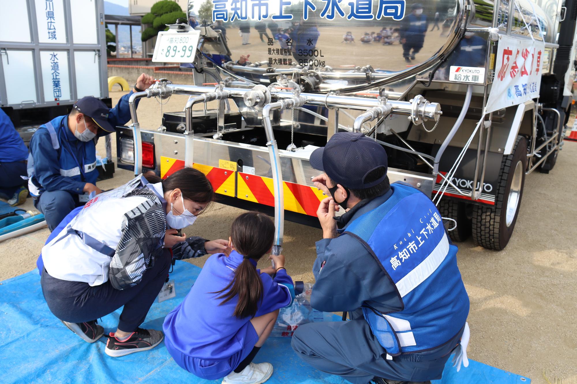 給水車から水を汲みとる
