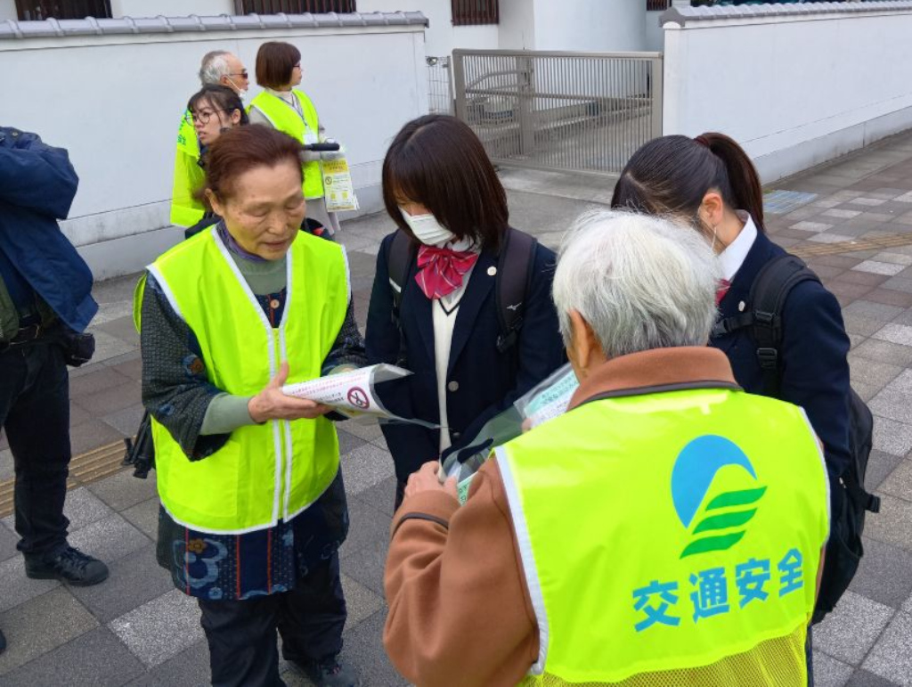通学中の学生へ、点字ブロックのチラシを配布