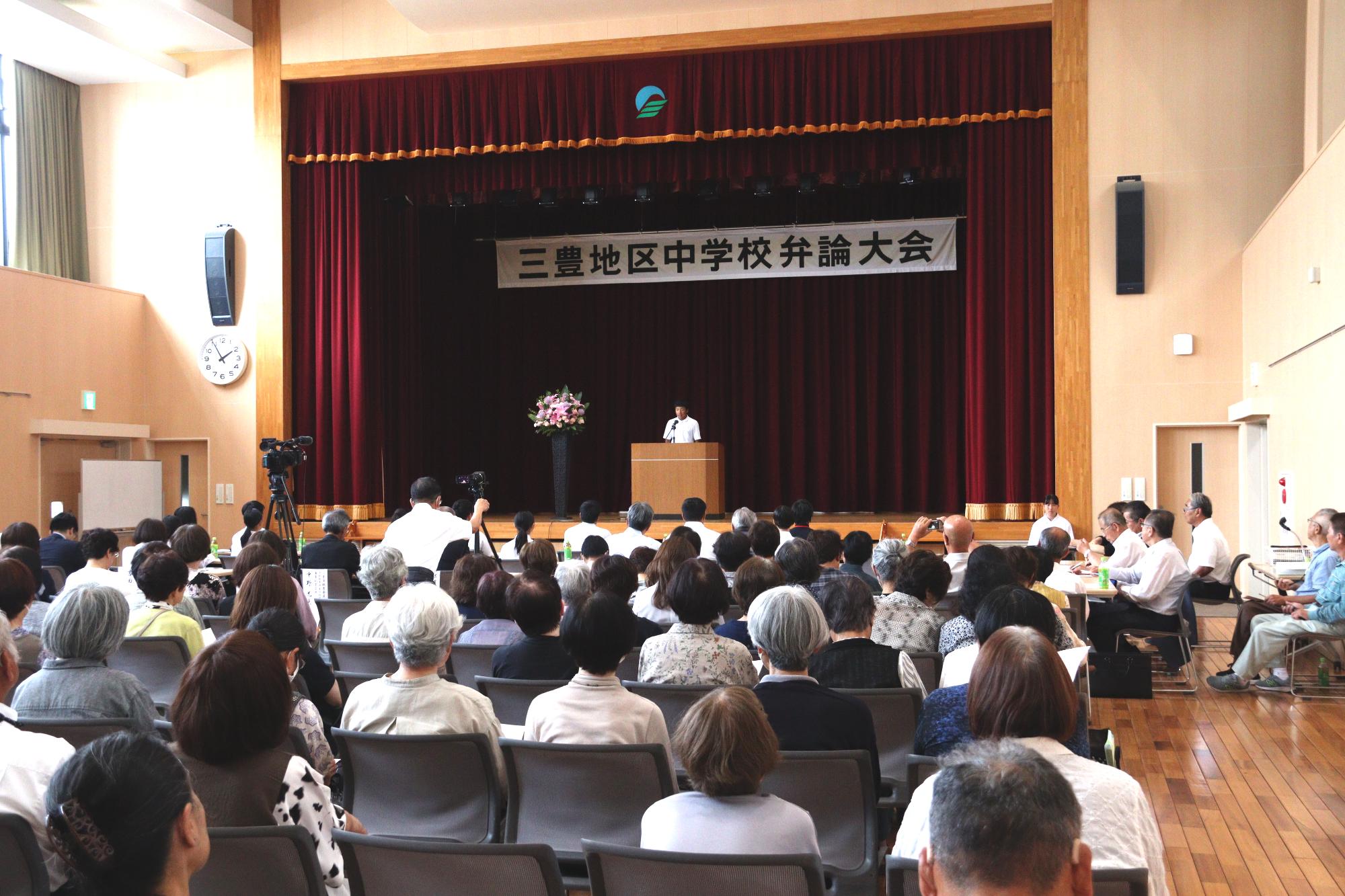 たくさんの観客の前で堂々と熱弁する中学生たち