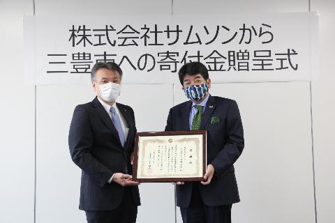 ▲感謝状を持つ山下市長（左）と株式会社サムソン吉岡社長（右）